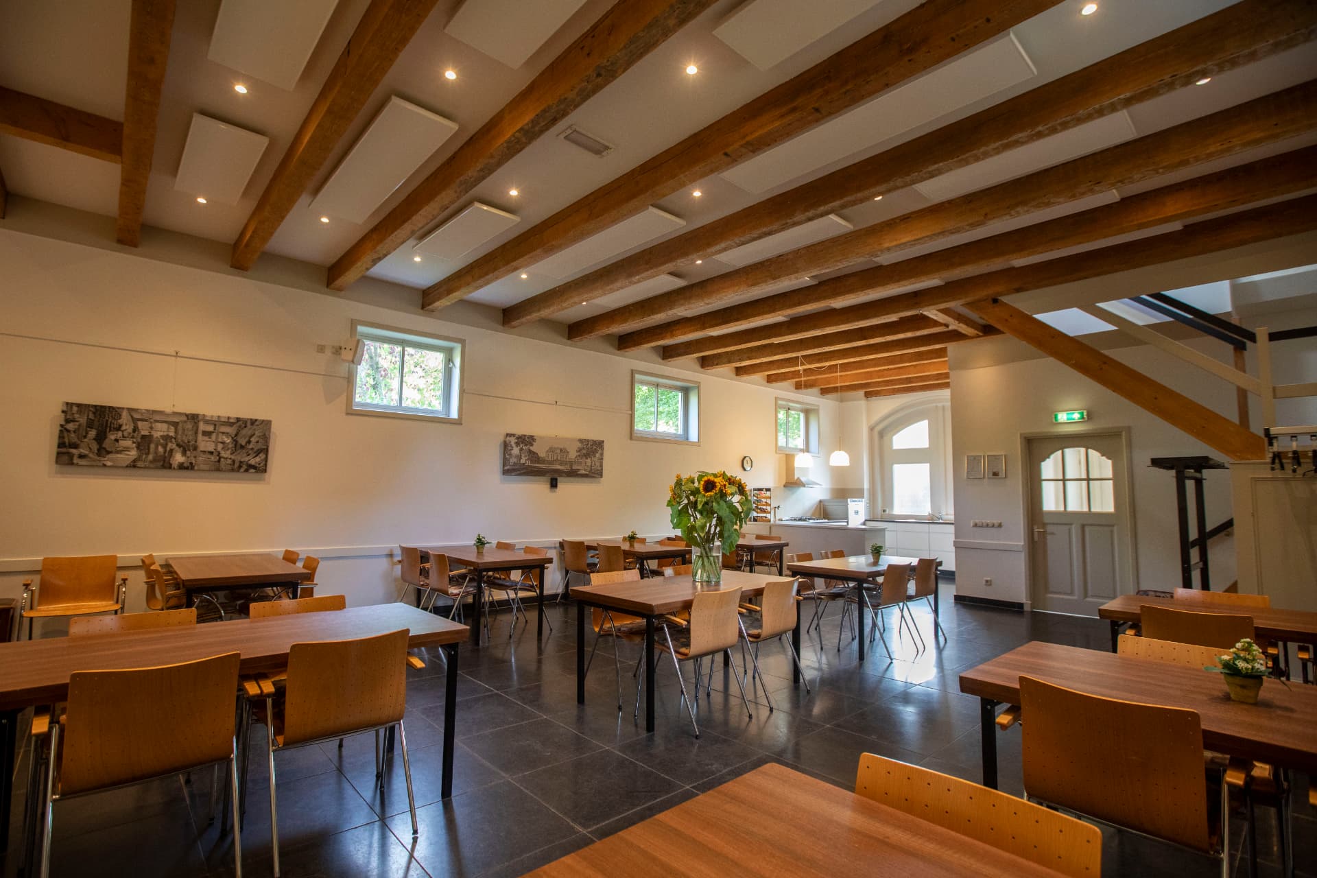 Het Koetshuys met houten balkenplafond, tafels en stoelen