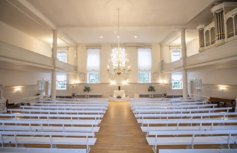De Grote Zaal met witte banken, kroonluchters en orgel